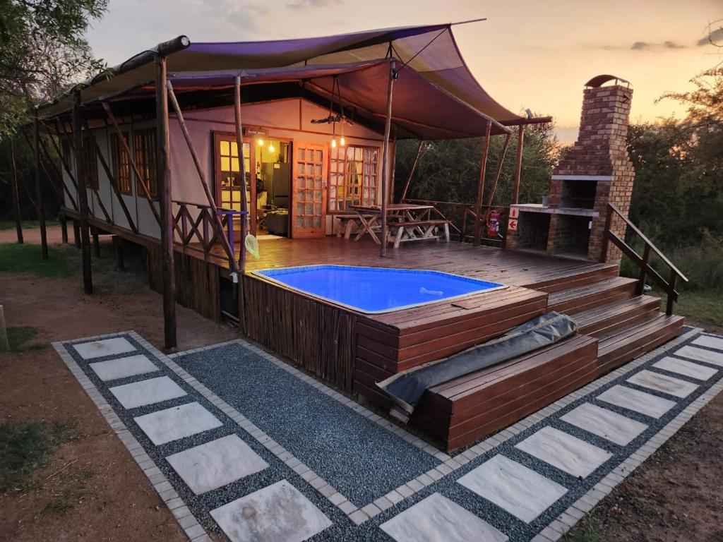 a house with a swimming pool and a tent at Jabula Bush Camp in Klipdrift