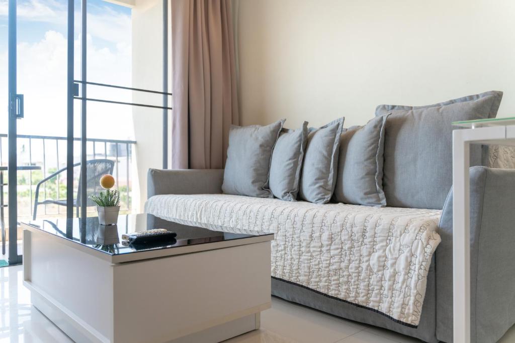 Ban SuanにあるThe Lago Apartmentsのソファとガラスのテーブルのあるリビングルーム