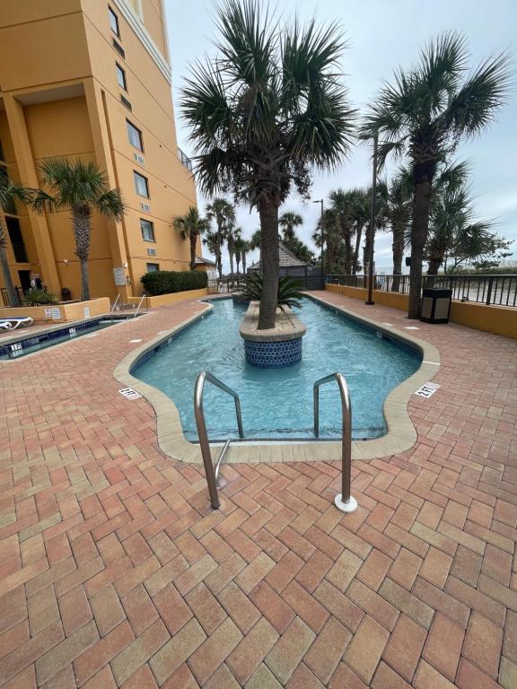 a swimming pool with palm trees in a building at Caravelle Resort in Myrtle Beach