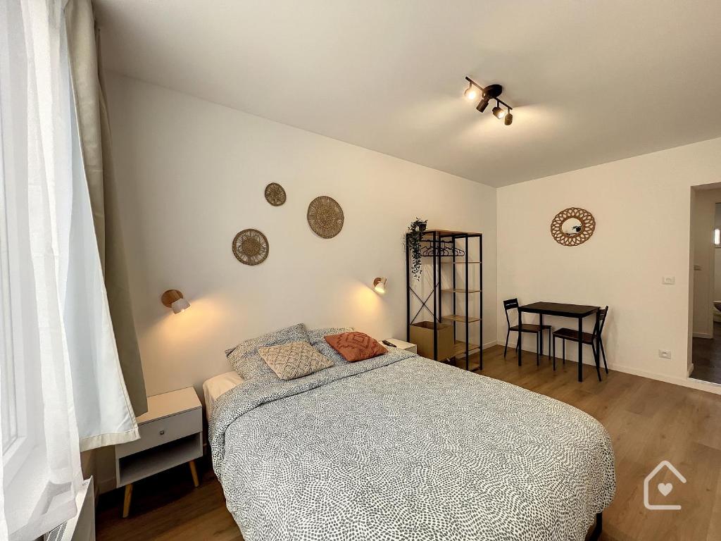 een slaapkamer met een bed en een tafel bij Les studios d'Elina in Châtellerault