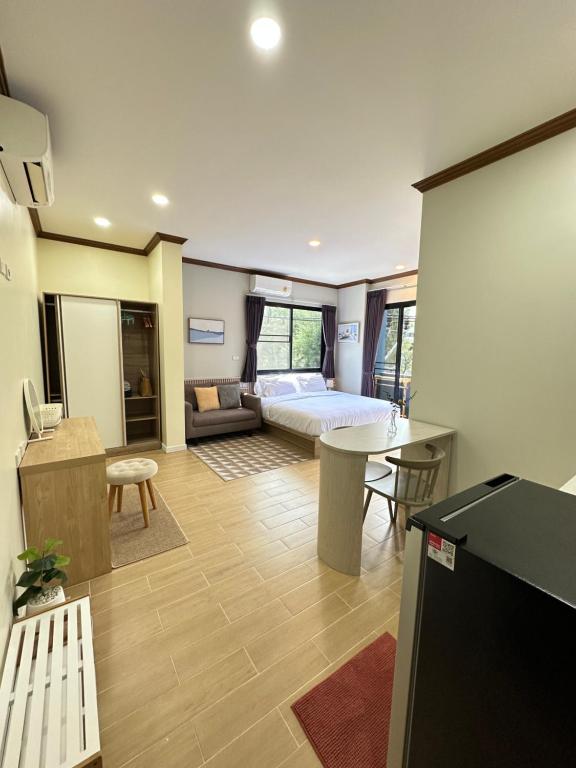 a living room with a bed and a desk and a kitchen at Kata Noi Place floor3 in Kata Beach