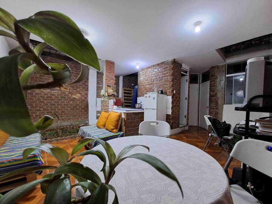 un salon avec une table et une plante dans l'établissement Casa amoblada con cochera, à Ica