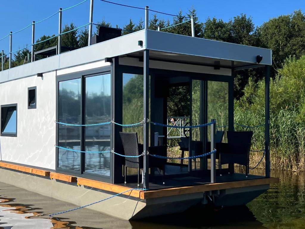 a small house on a boat in the water at Hausboat David in Hrdoňov