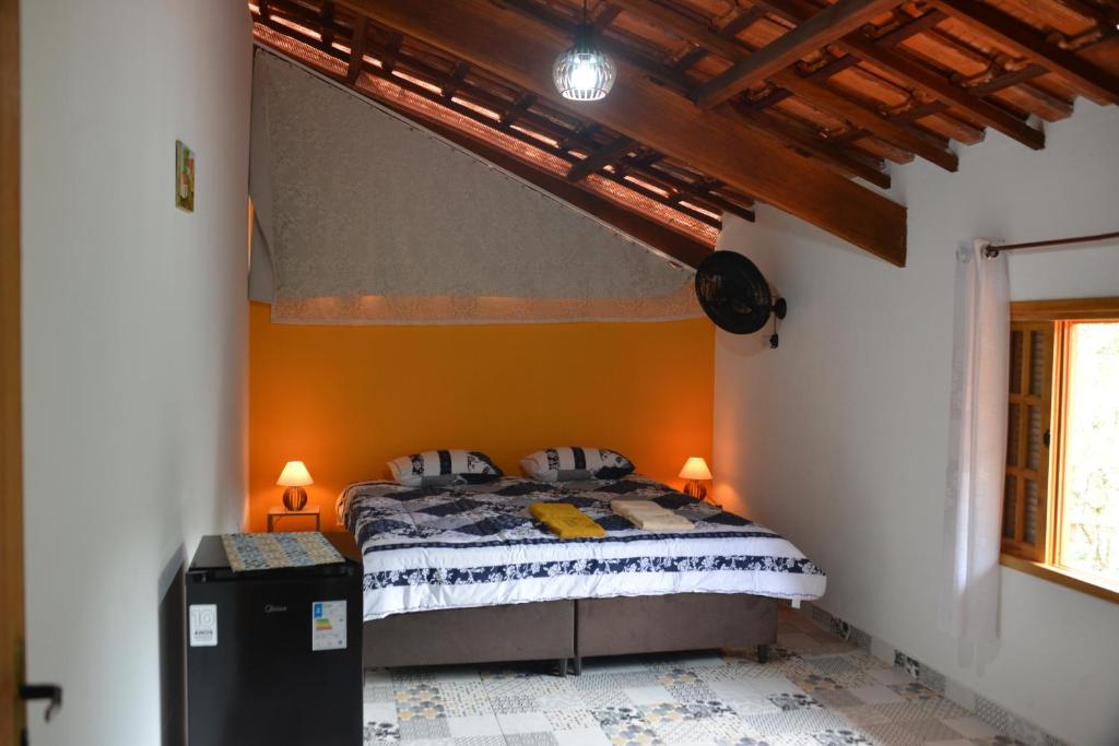 - une chambre avec un lit dans une pièce aux murs orange dans l'établissement Rancho Potala, 