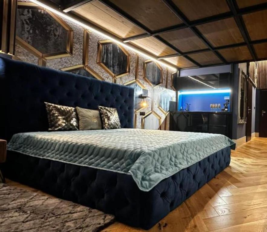 een slaapkamer met een groot bed met een blauw hoofdeinde bij LUX 114 APARTMENT in Košice