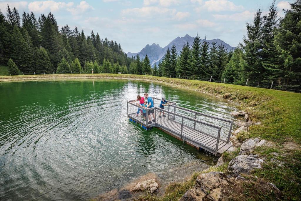 two people standing on a dock in the middle of a lake at Haus Rätikon in Brand