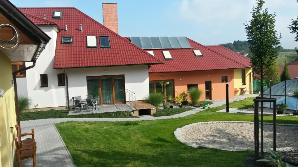 una casa con techo rojo y patio en Apartmány Comfort en Střílky