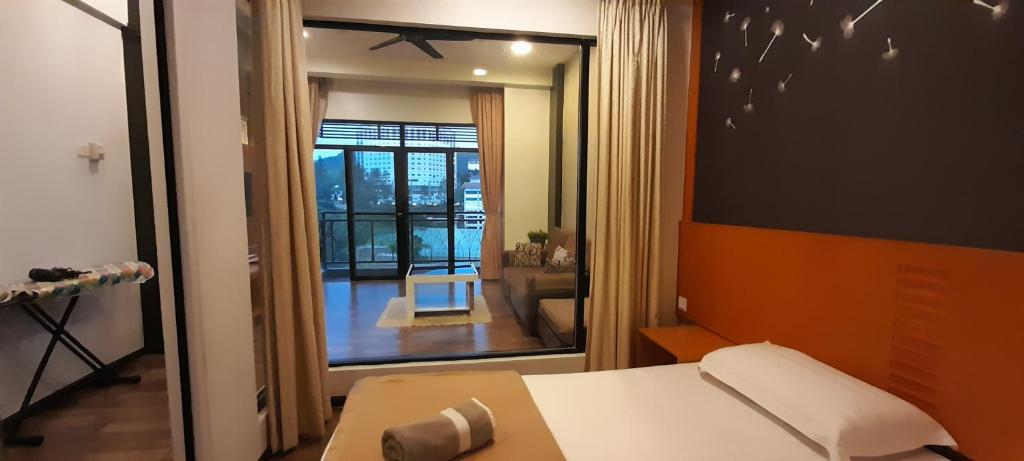 a room with a bed and a view of a living room at aparthotel cameron in Brinchang