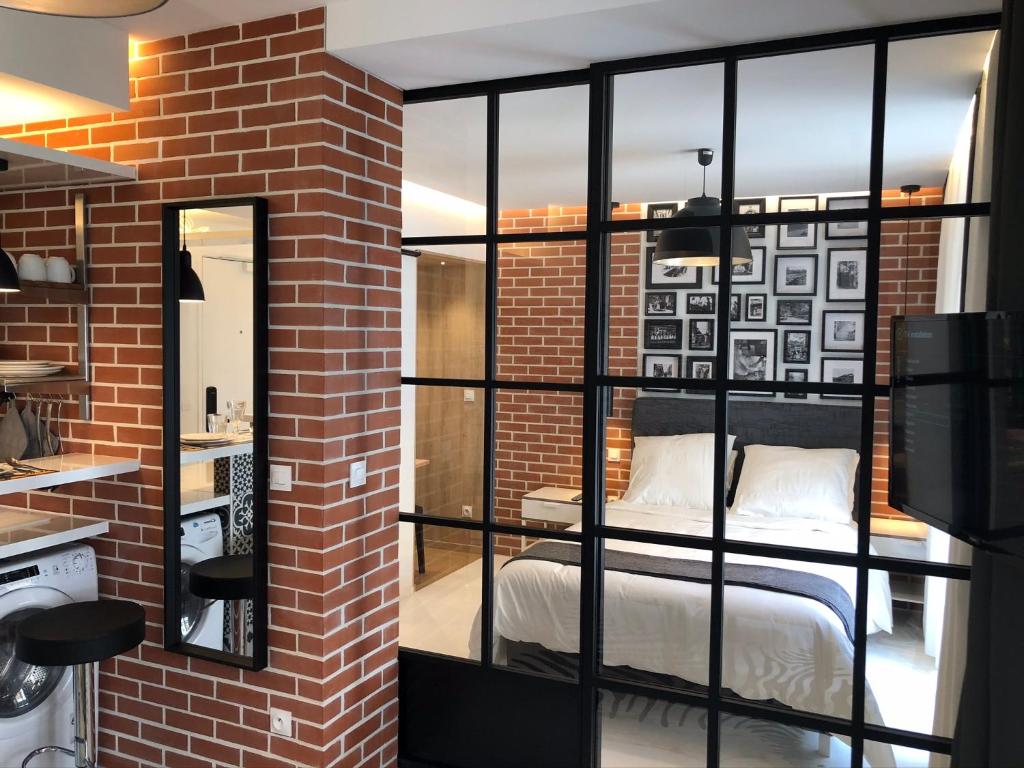 a room with a bed in a brick wall at Appartement Hainaut Paris XIXème- Tout Equipé! in Paris