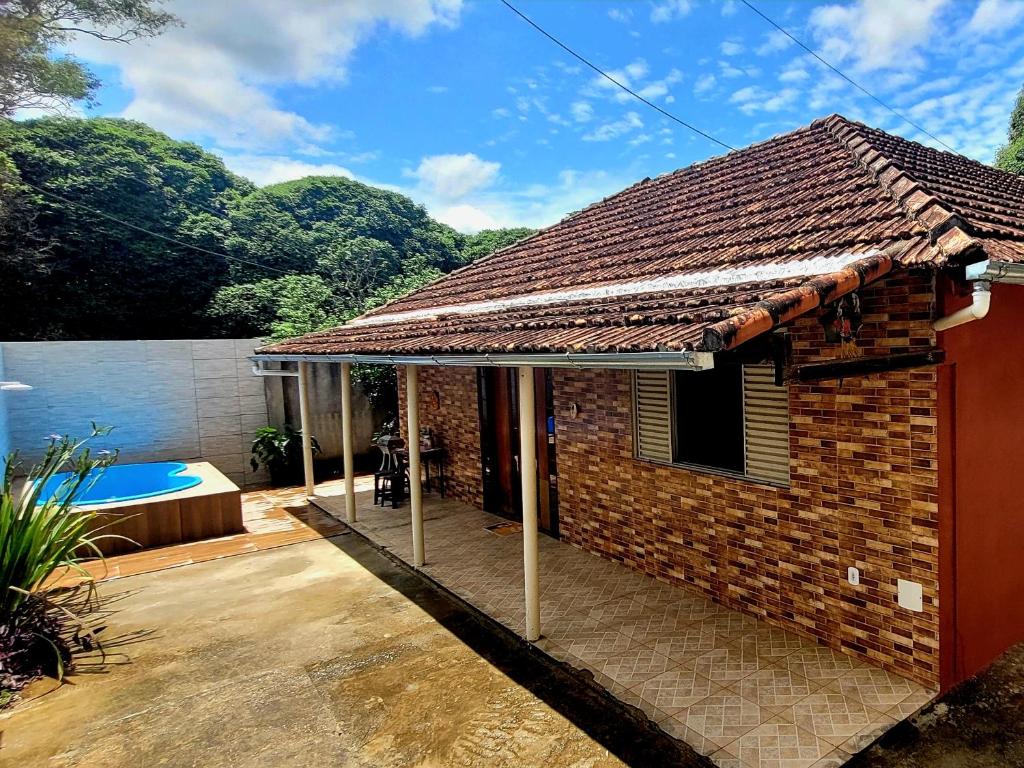 a brick house with a roof on a patio at Casa com piscina próxima a pontos turísticos in São Lourenço