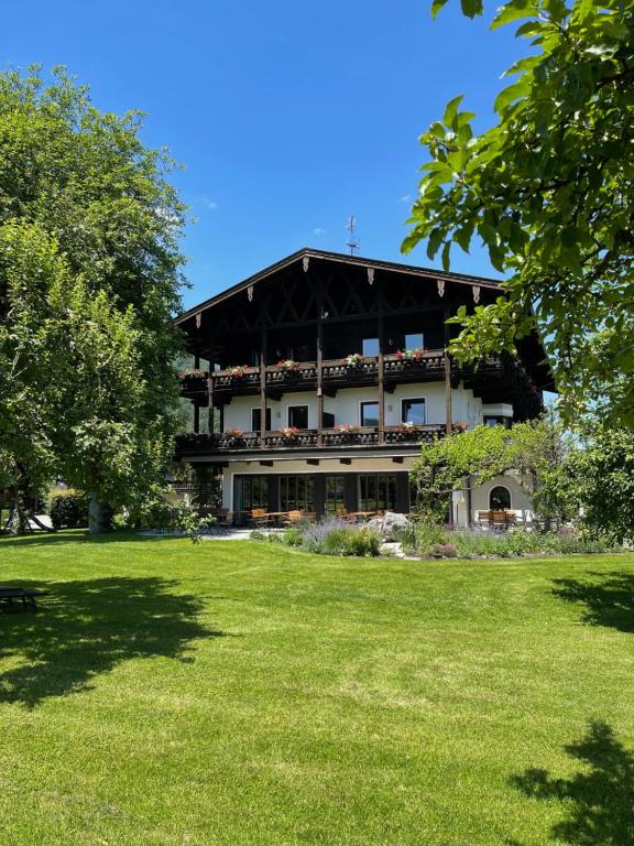 ein Gebäude mit einem Grasfeld davor in der Unterkunft Alpenhof Landhotel Restaurant in Oberaudorf