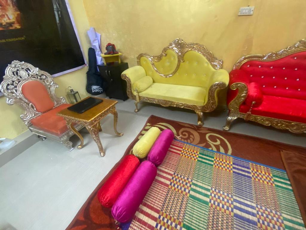 a living room with two chairs and a couch at Mahavatar Babaji Farm Stay in Bangalore