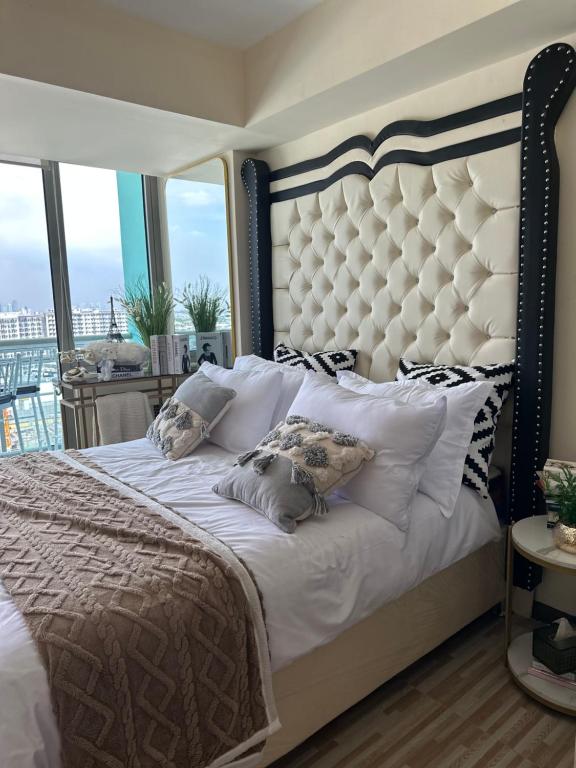 een slaapkamer met een groot wit bed met kussens bij Azure Urban Resort - St Tropez Tower Staycation Unit with a European Touch in Manilla