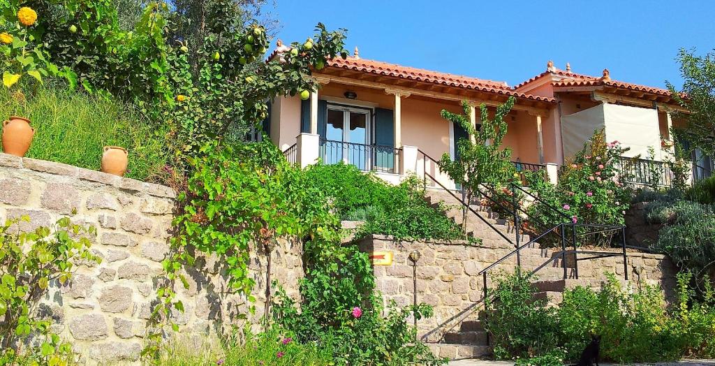 una casa en una colina con una pared de piedra en Ktima Apostolou, en Aspropótamos