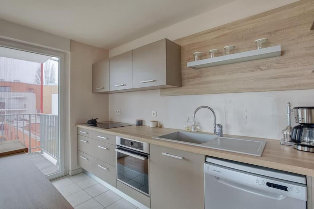 a kitchen with a sink and a stove top oven at Soultz - Bel app avec balcon dans résidence - Strasbourg in Strasbourg