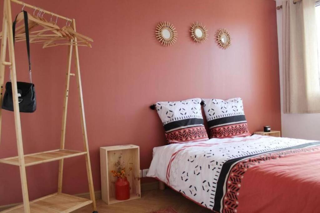 um quarto com uma cama e uma parede rosa em Cocon Perret - Plage du Havre - Design & Moderne em Le Havre