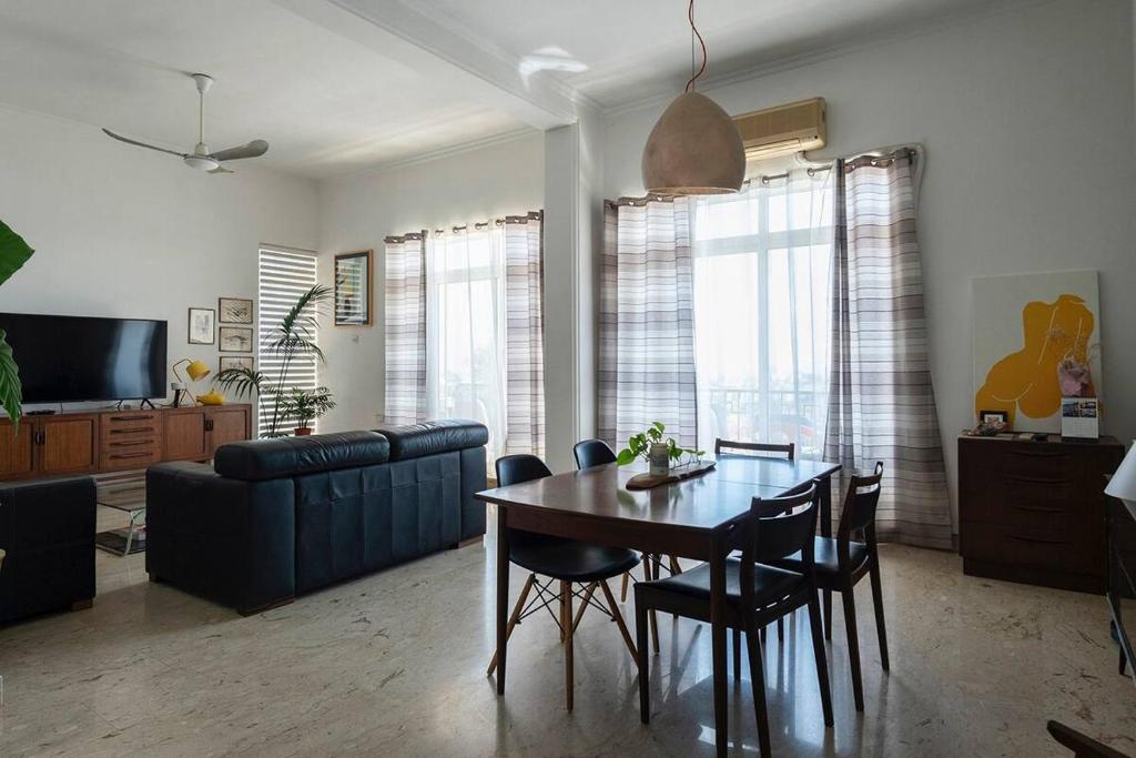 uma sala de estar com uma mesa e cadeiras e um sofá em Spacious modernist Apt with views & pool em Tal-Mejda