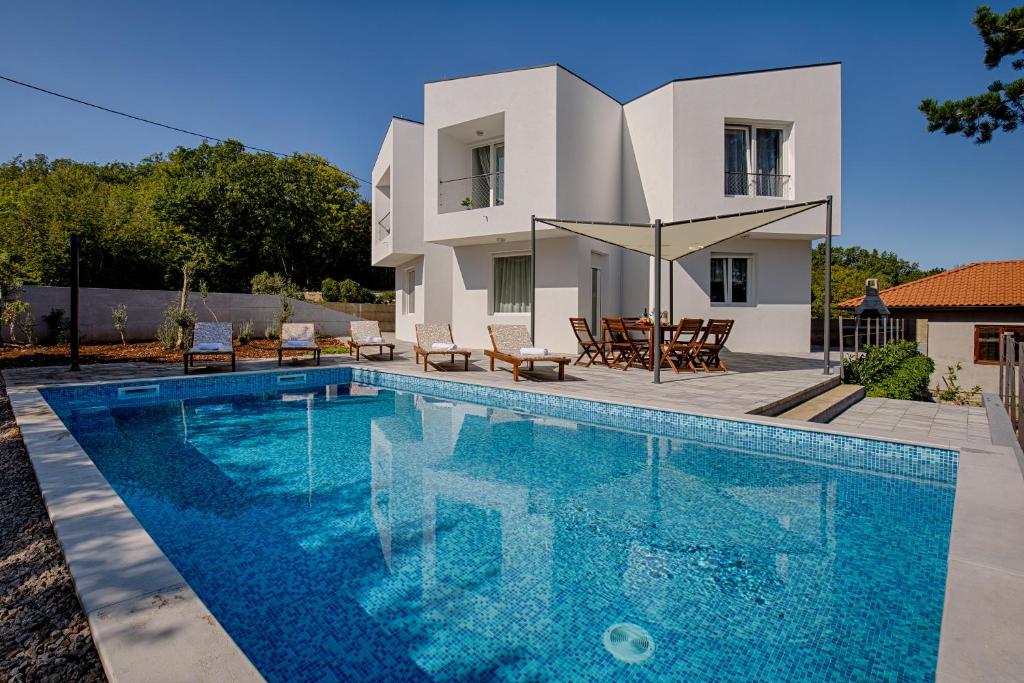 una villa con piscina y una casa en Modern villa with pool, whirpool in quiet area - by Traveler tourist agency Krk ID 2180, en Gostinjac