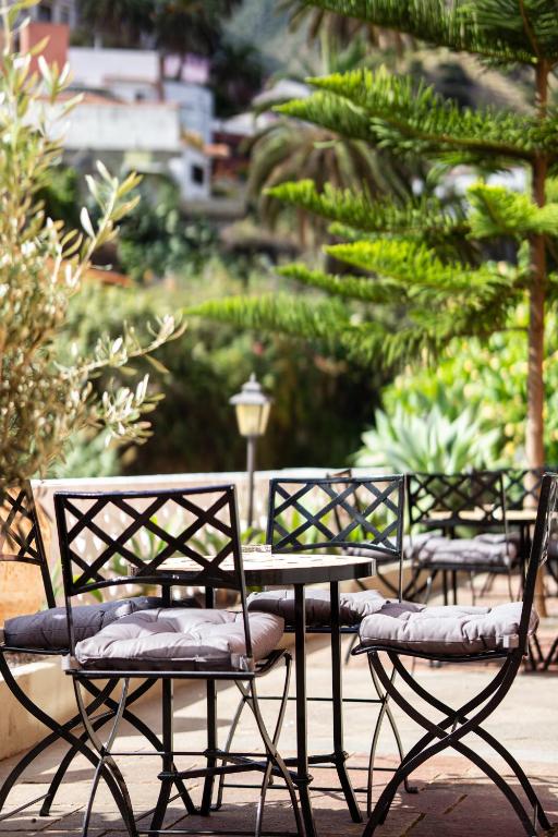 a group of chairs and a table in a garden at Tamahuche Hotel Rural in Vallehermoso