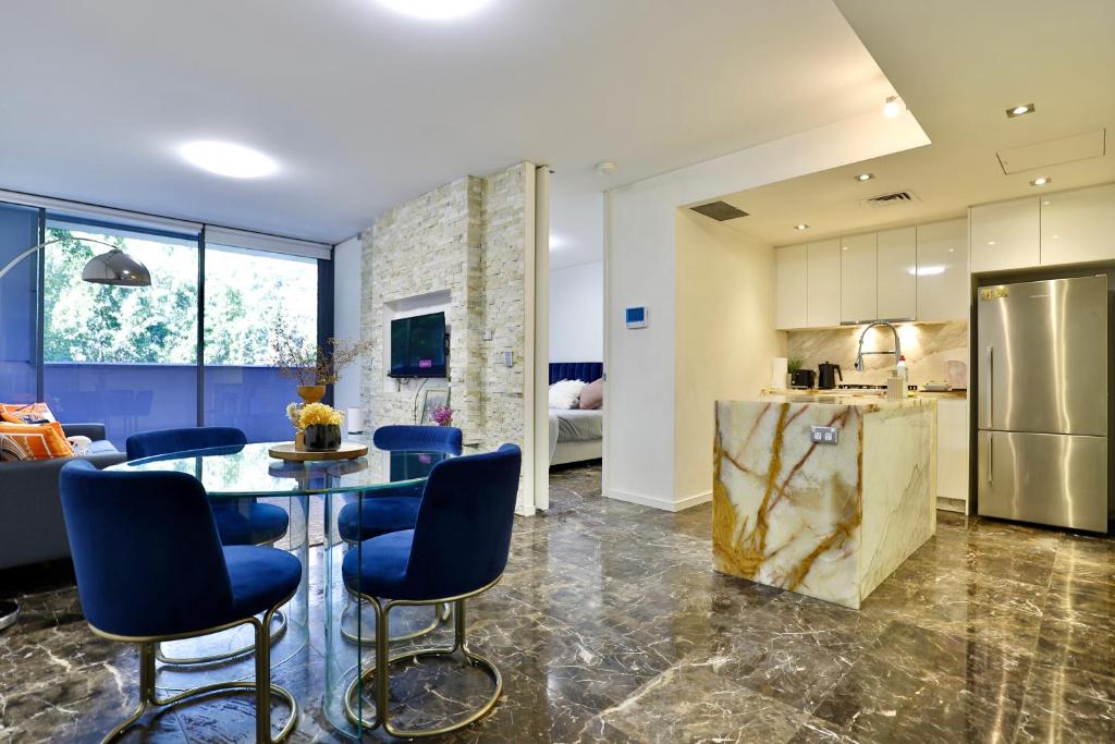 a kitchen and living room with a table and chairs at CBD Harbour Retreat - Lovely 2BR Home in Sydney