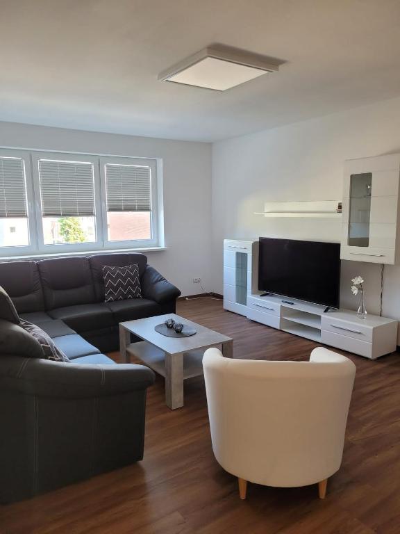 a living room with a couch and a tv at Schöne einfache Ferienwohnung zwischen Stadt und Meer in Wilhelmshaven