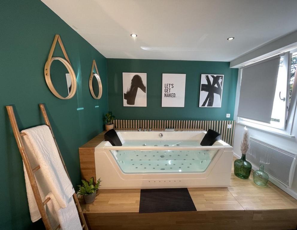 a bath tub in a bathroom with green walls at The Green Garden Spa & Serenity in Mittelhausbergen