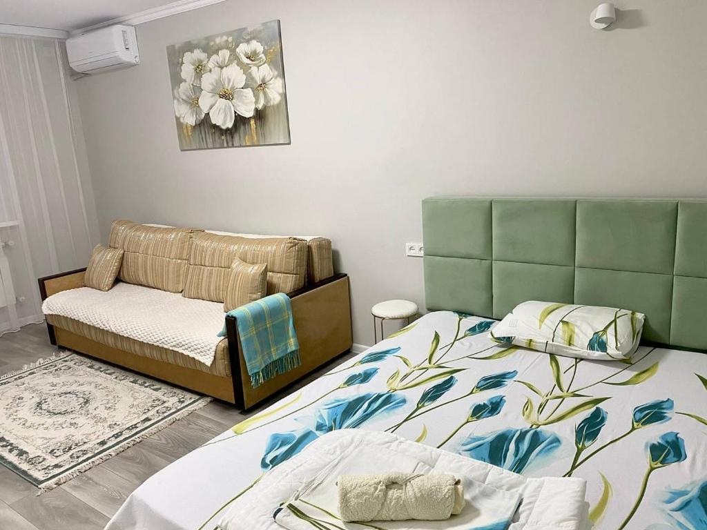 sala de estar con 2 camas y sofá en Апартаменты аэропорт 1, en Turksib