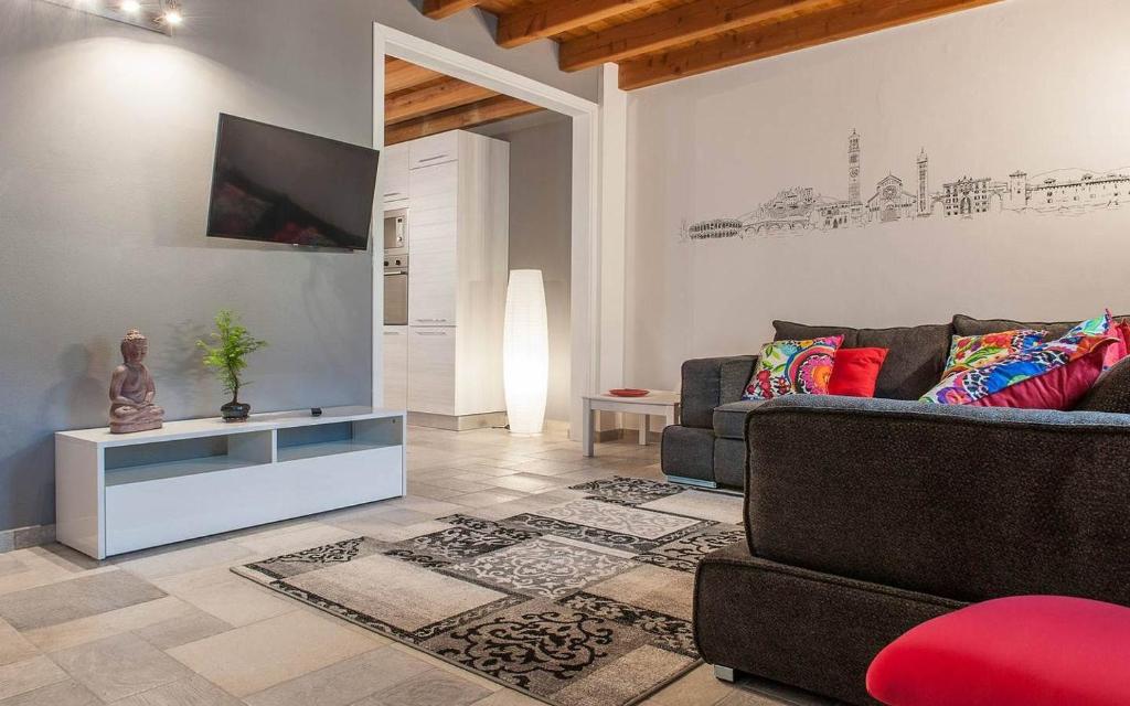- un salon avec un canapé et une télévision dans l'établissement Appartamento San Martino, à Vérone