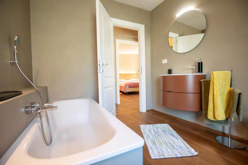 uma casa de banho com uma banheira, um lavatório e um espelho. em La Noix - Alloggi ad uso turistico - VDA - ARVIER - n 0041 e n 0042 em Arvier