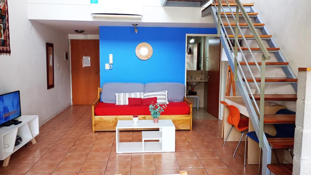 a bedroom with a bed with a blue wall at Duplex dos ambientes con terraza propia y parilla in Buenos Aires