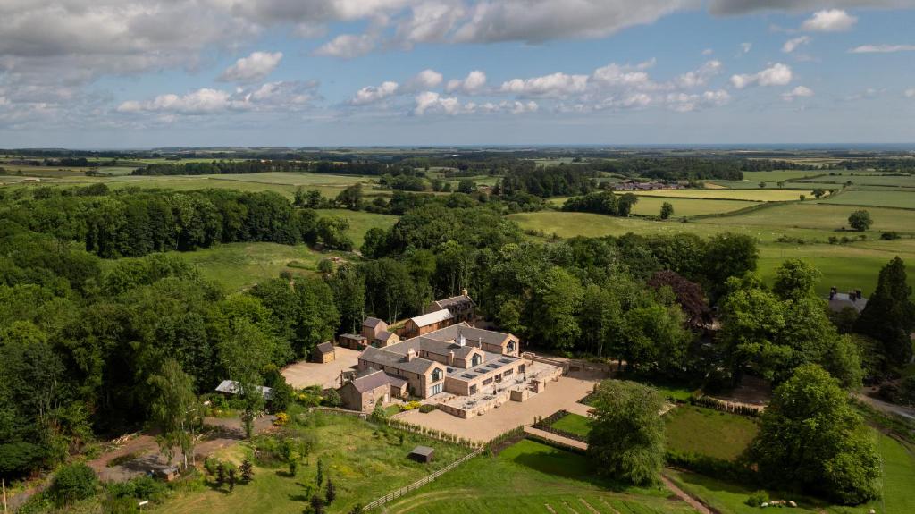 eine Luftansicht eines großen Hauses auf einem Feld in der Unterkunft The Tempus at Charlton Hall Estate in Alnwick