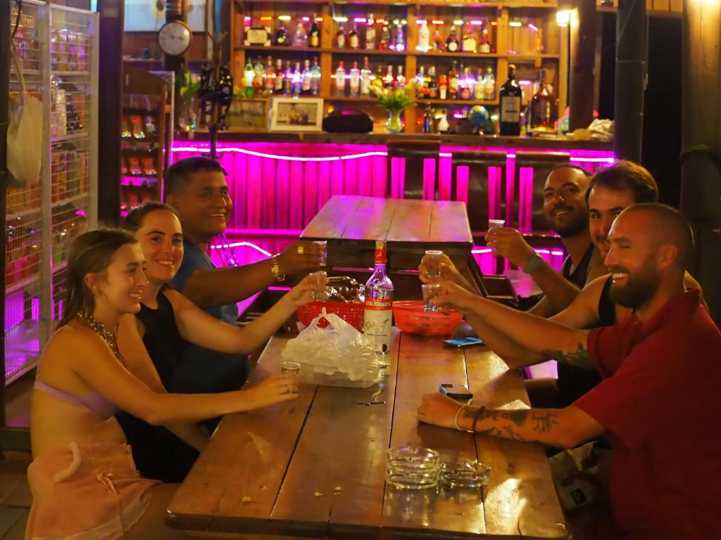 un grupo de personas sentadas en una mesa en un bar en Coconutbeach Bungalows Party Hostel en Koh Rong Island