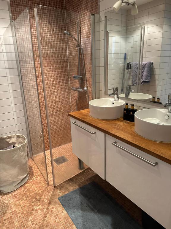 a bathroom with two sinks and a shower at Old and charming penthouse in Oslo