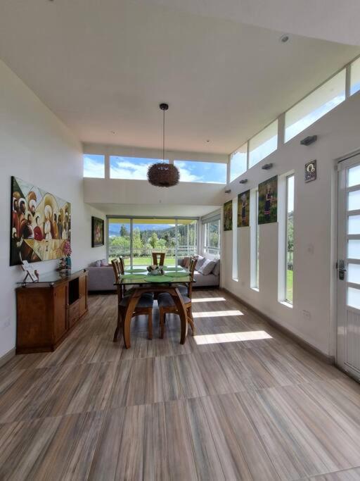 Una gran sala de estar con una mesa y un sofá. en Casa Villa Container, en Tibasosa