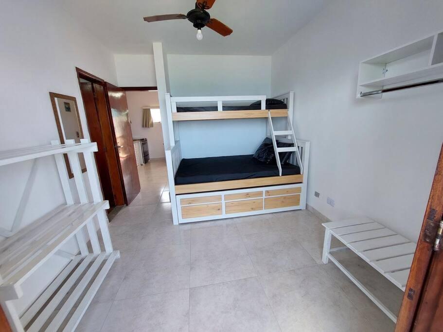 a room with two bunk beds and a ceiling fan at Ap Vista Mar em Caraguatatuba in Caraguatatuba