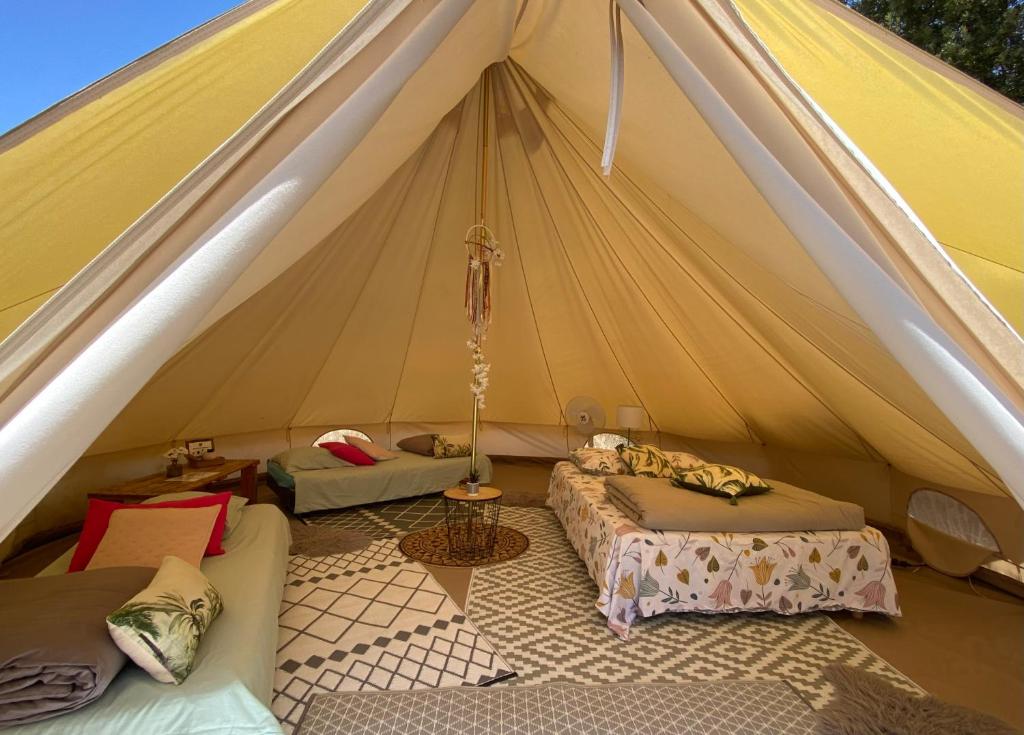 uma tenda com duas camas e um sofá num quarto em Tente inuit cocooning em Urtaca