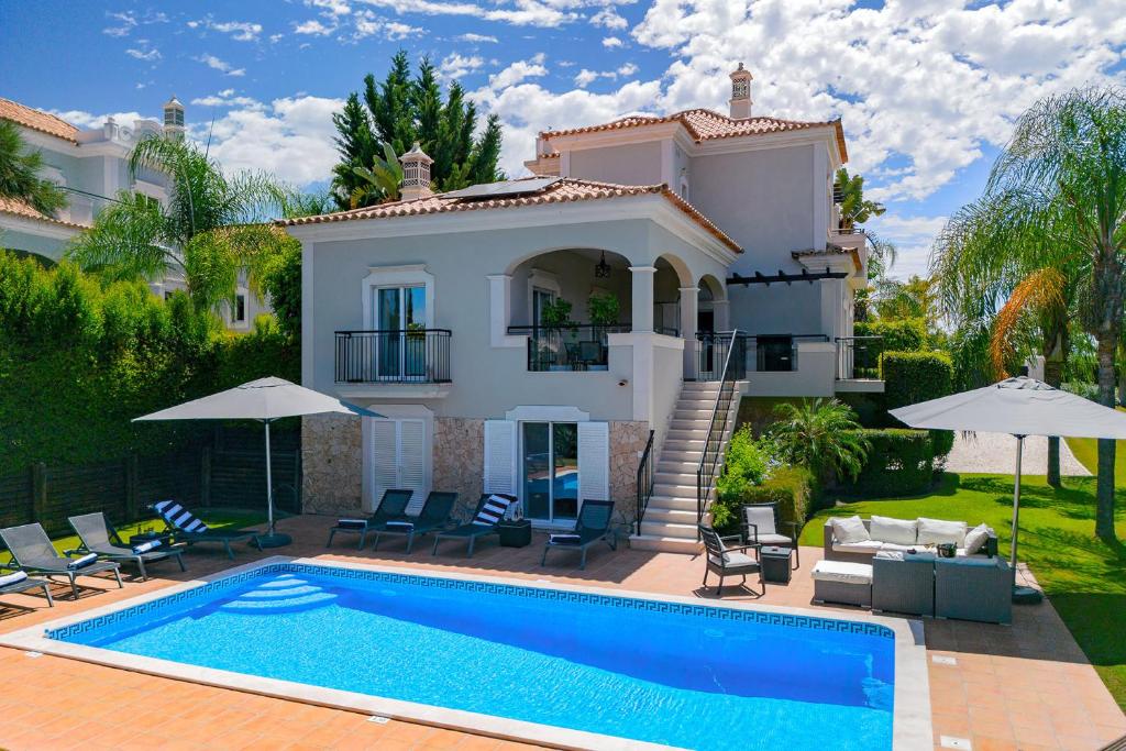 eine Villa mit einem Swimmingpool vor einem Haus in der Unterkunft Villa Simone in Almancil