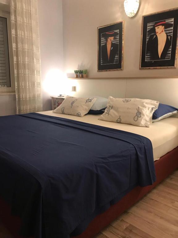 ein Bett mit blauer Bettwäsche und Kissen in einem Schlafzimmer in der Unterkunft Villa Marica in Trogir