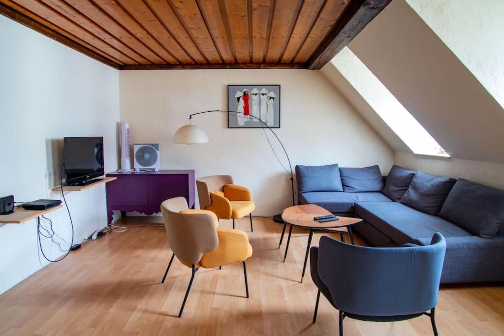 een woonkamer met een blauwe bank en stoelen bij Le Molsheim - Grand appartement proche Musée dArt Moderne in Straatsburg