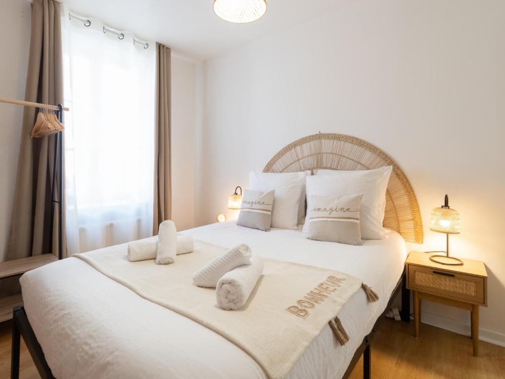 1 dormitorio con 1 cama blanca grande y toallas. en La Petite Histoire, en Vienne