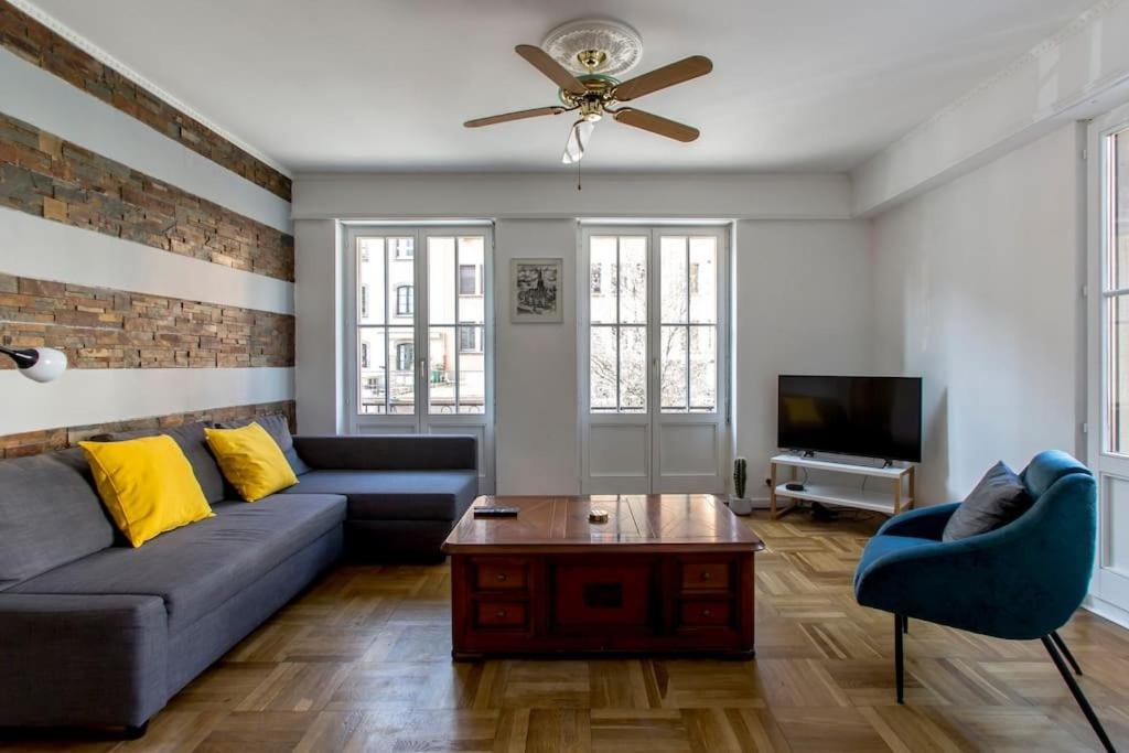 un salon avec un canapé et un ventilateur de plafond dans l'établissement L'Escapade Urbaine - Exceptionnel Charmant 3 pièces proche Cathédrale, à Strasbourg