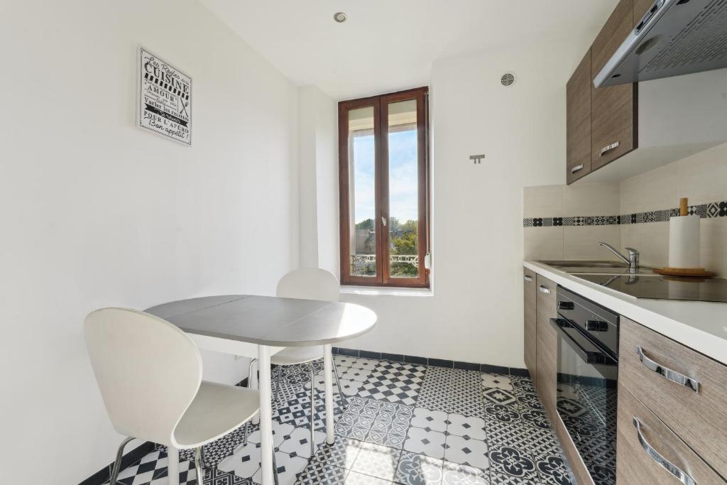 une cuisine avec une table et des chaises et une fenêtre dans l'établissement Budget appart avec parking au centre-ville, à Charleville-Mézières