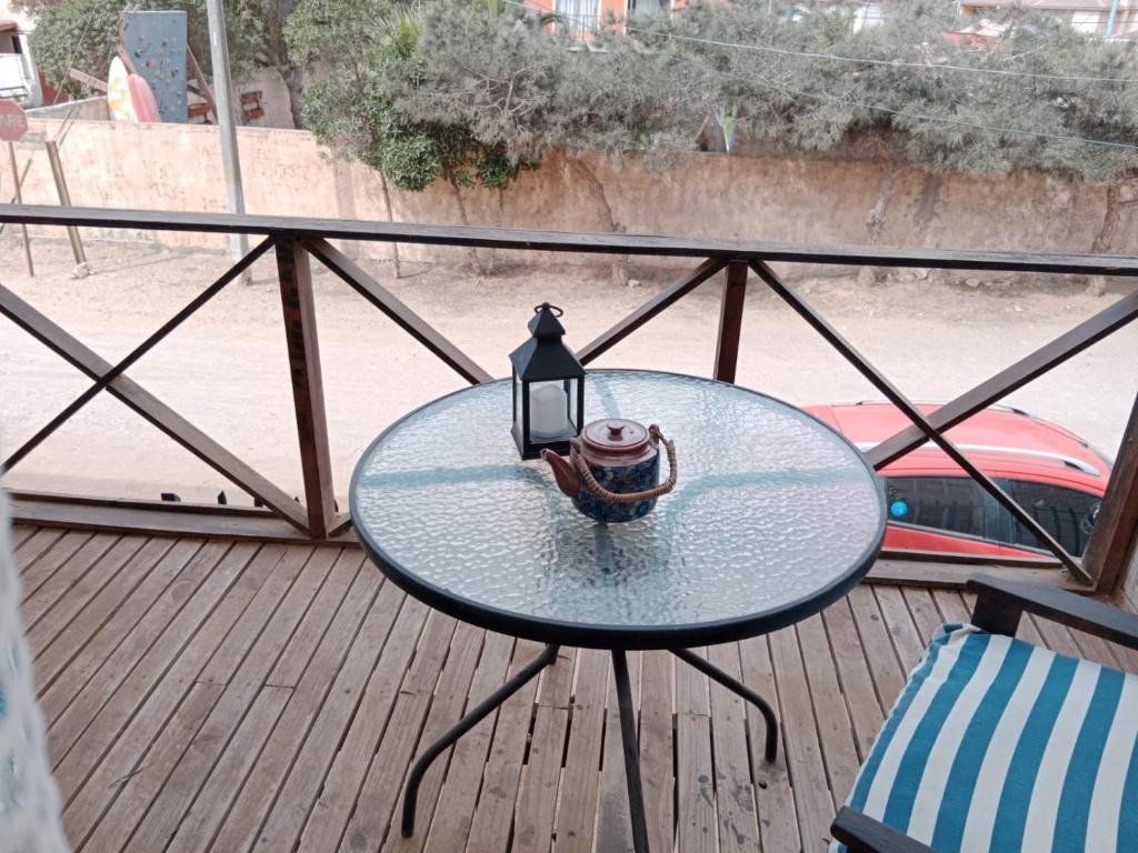 a glass table with a lamp on a balcony at Cabaña playa in Coquimbo