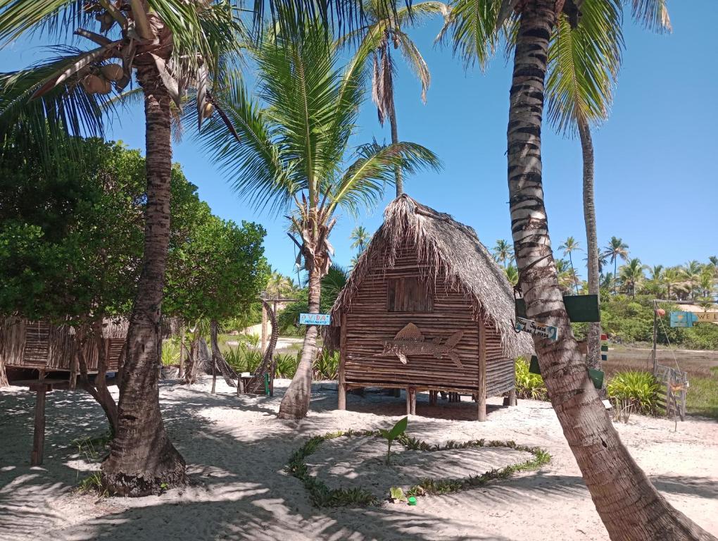 a small hut on the beach with palm trees at Cabana bem - ti - vi in Camaçari