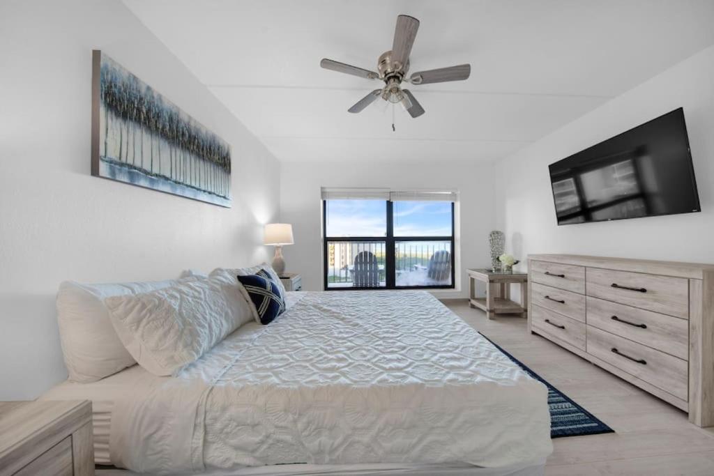 Un dormitorio con una cama y un ventilador de techo. en Amazing 6th floor beachfront condo wonderful views, en South Padre Island