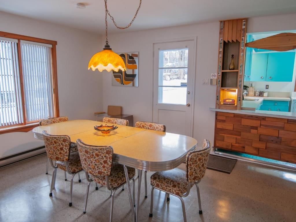 una sala da pranzo con tavolo e sedie di La Maison Gagnon a Saguenay