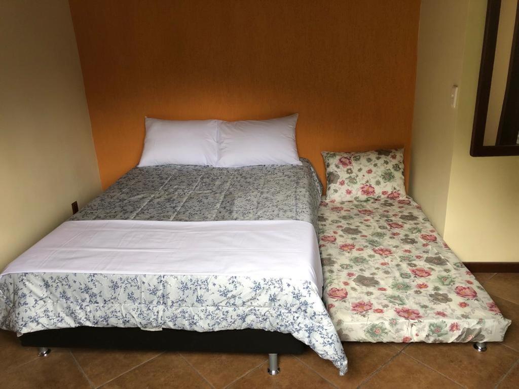 two beds in a small room with at Recanto dos Pássaros em Petrópolis in Petrópolis