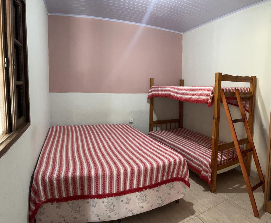 1 dormitorio con 2 literas y escalera en Kitnet em Cabo Frio 04, en Cabo Frío