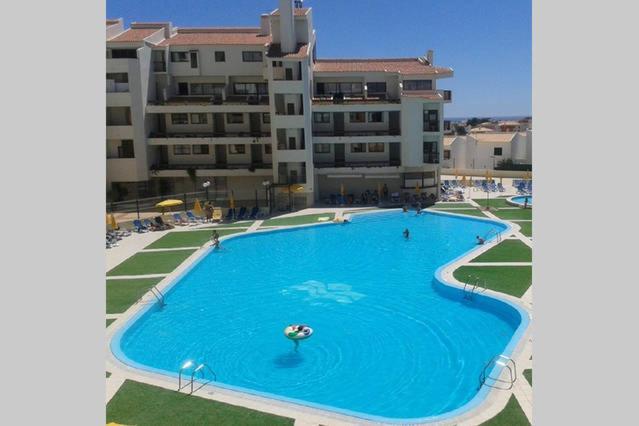 a large swimming pool in front of a building at Apartamento Ariadna in Albufeira