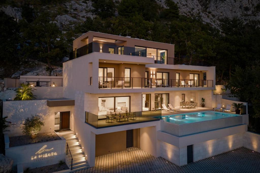 a large house with a swimming pool in front of it at Luxury Villa La Mirada in Omiš